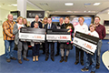 The 27th Rittal Cup broke all previous records: Andreas Huck (middle) and Norbert Peter (fifth from right) handed over a total of €10,400 to representatives of the church-run care centre in Eschenburg, the “Charlie und Lotte” grief counselling service, the German Red Cross’s Dietzhölztal branch and the SG Dietzhölztal sports club.