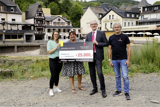 Rainer Reissner (2. v. r.), Geschäftsführer Rittal Foundation, und Markus Betz (r.), Vorsitzender des Stiftungsvorstands, überreichen in der Nähe des zerstörten Bahnhofs von Altenahr 25.000 Euro an Isabel Haunhorst (l.) und Manuela Otto (2. v. l.) vom Verein „ahrlotsen e.V.“.